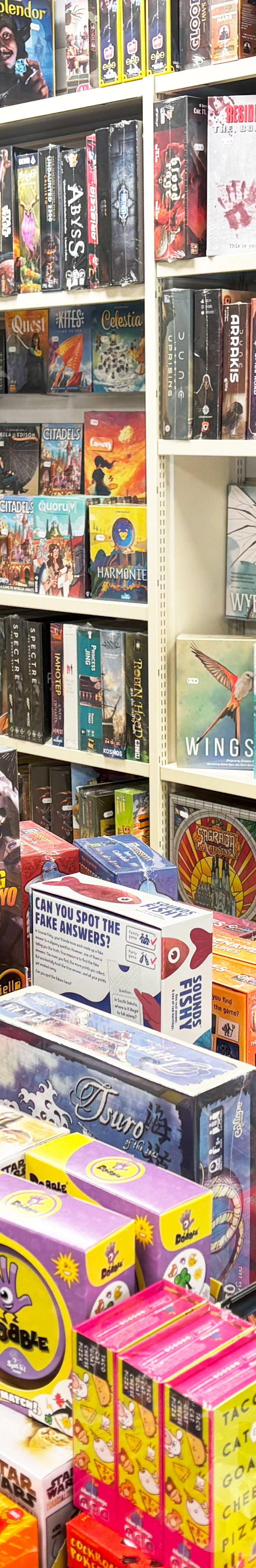 Shelves filled with various board games and card games in a store.