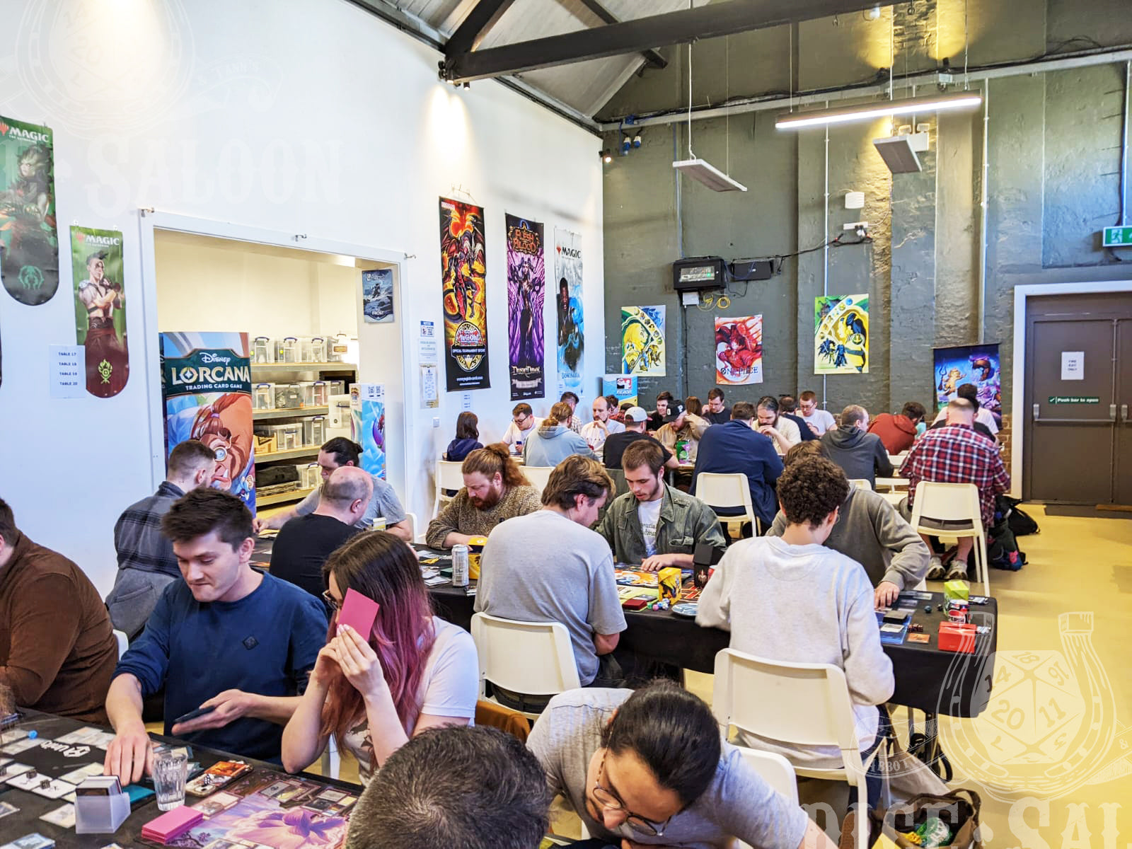 People playing board games in a casual setting with posters on the wall.